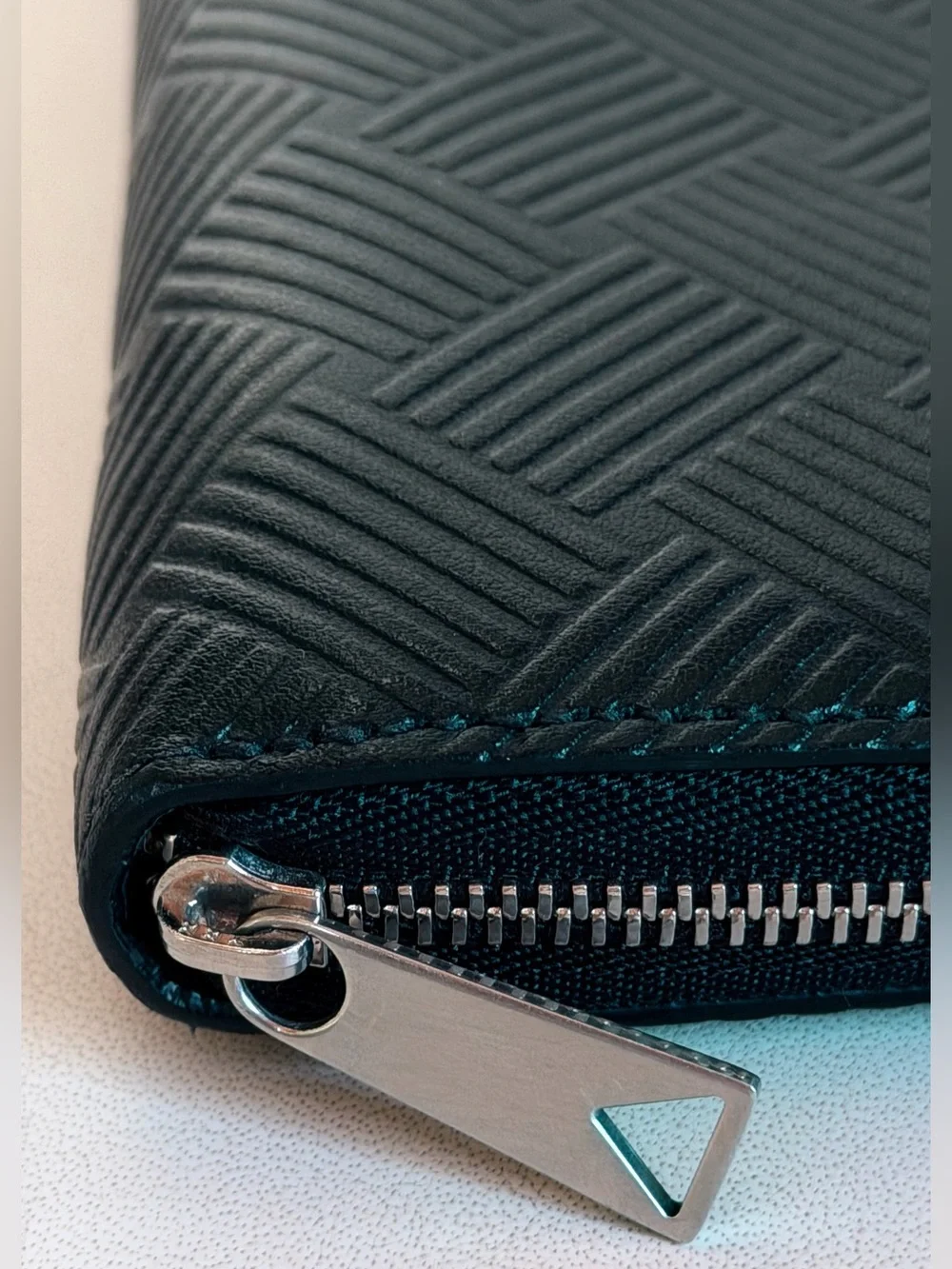 BOTTEGA VENETA Black Zip Around Wallet in Intrecciato Debossed Calfskin. UNISEX.